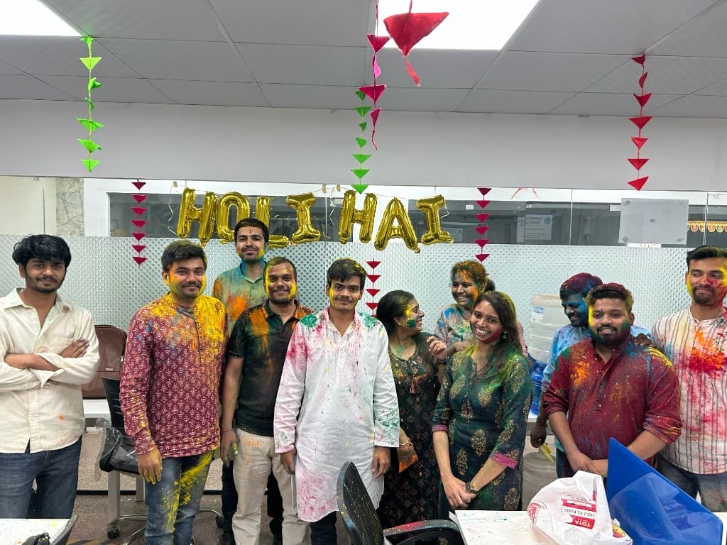 Team covered in Holi colors celebrating together