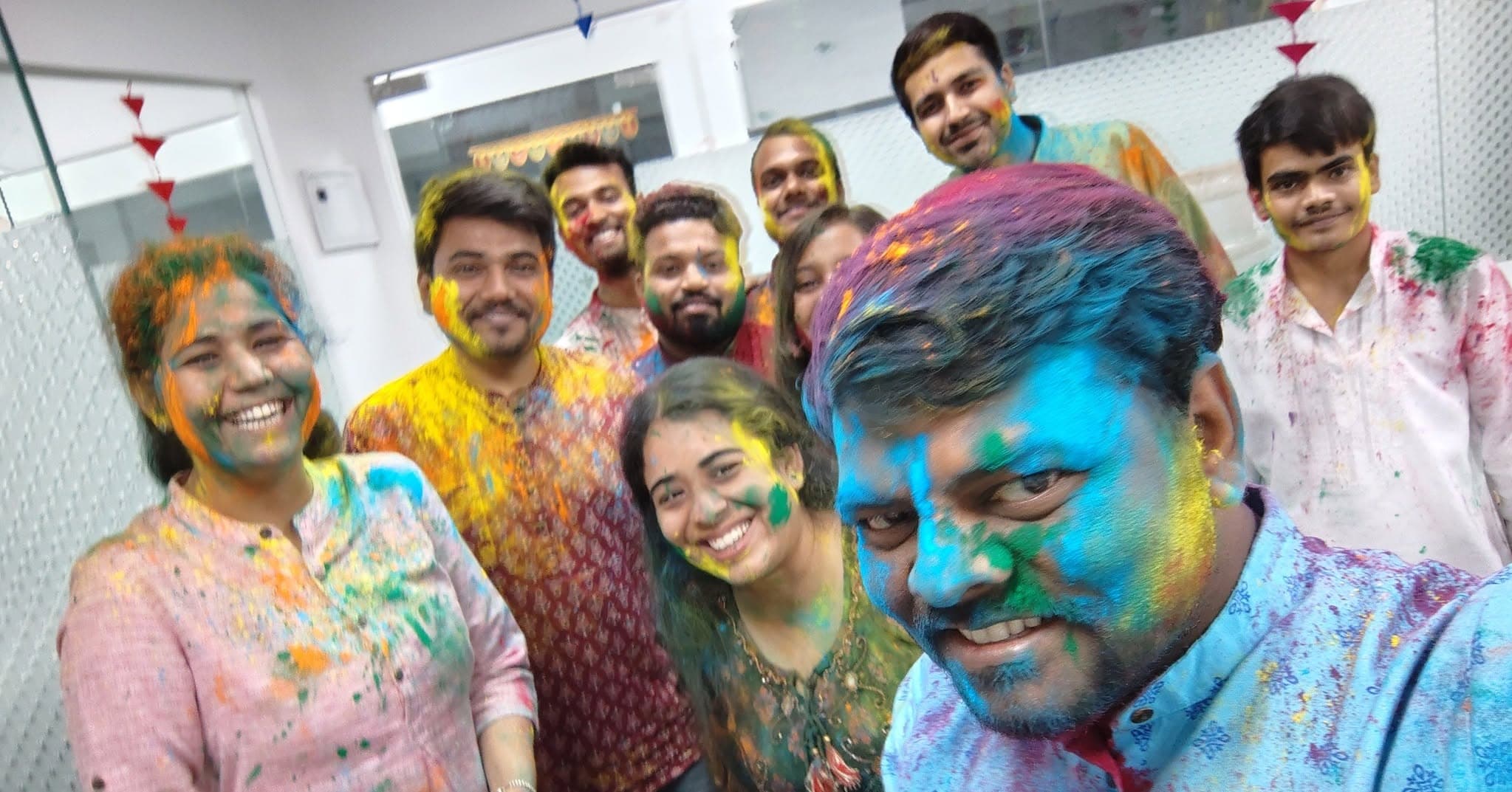 Colorful Holi group selfie in the office